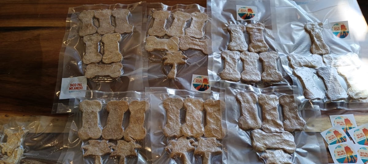 Múltiples bolsas de plástico con varios productos alimenticios organizados sobre una superficie de madera